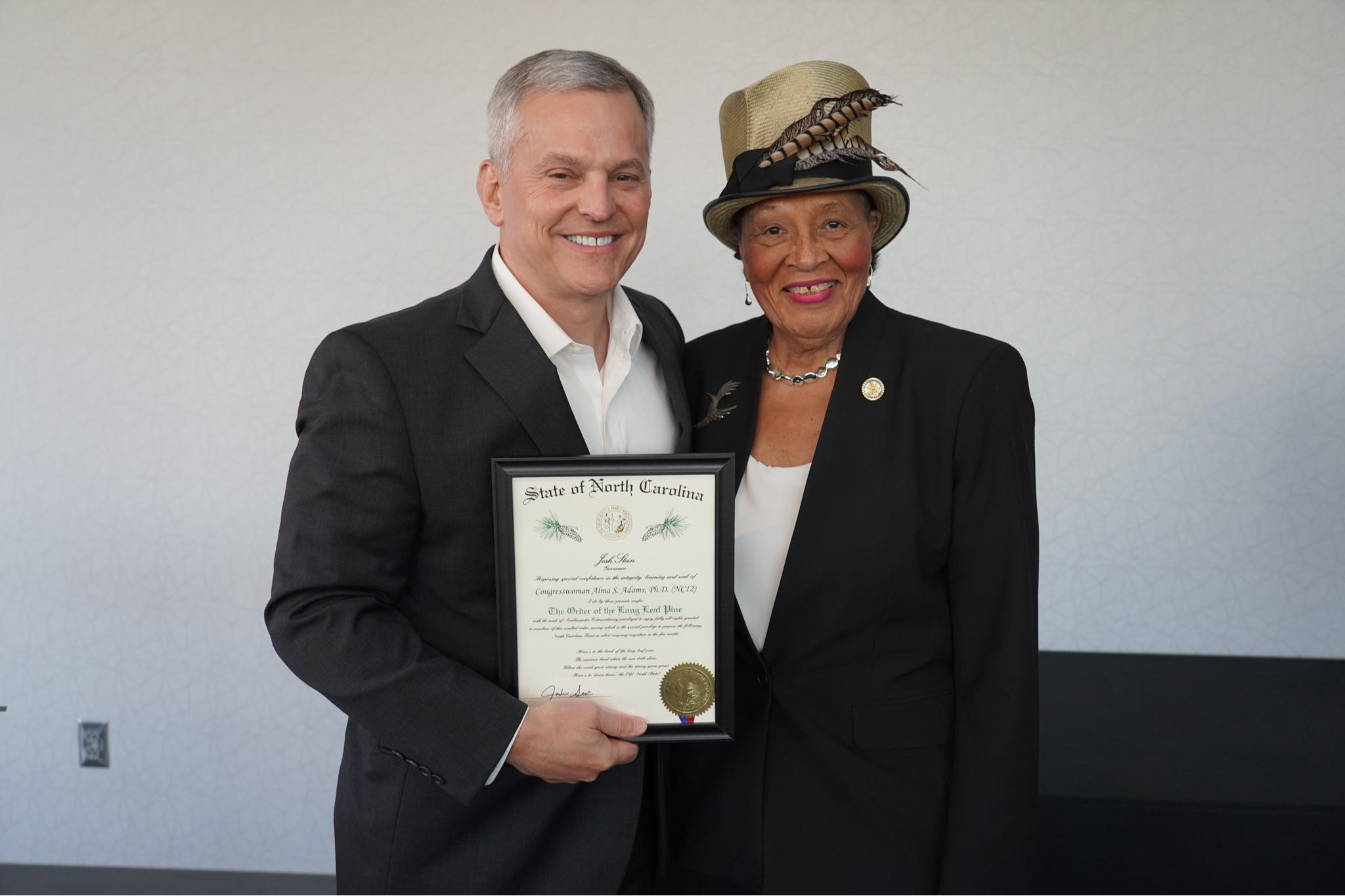Rep. Adams poses with Gov. Stein and a plaque for the Order of the Long Leaf Pine induction ceremony