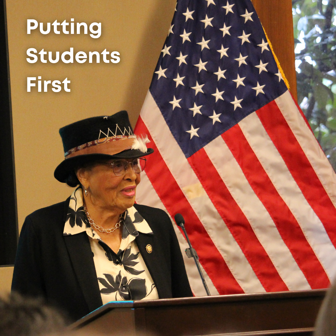 Rep. Adams speaks at a podium with an American flag behind