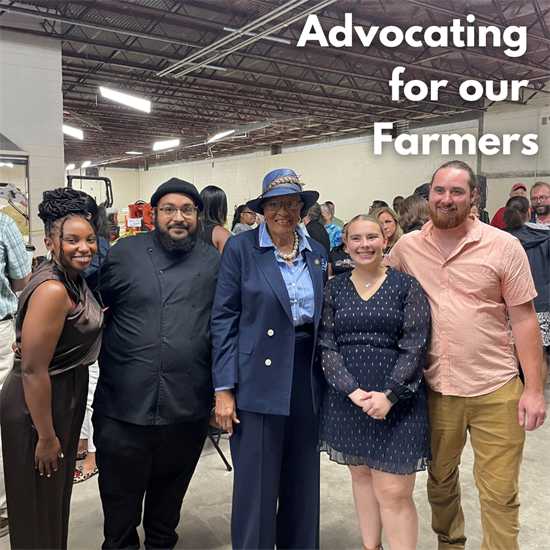 Rep. Adams poses with farmers at event