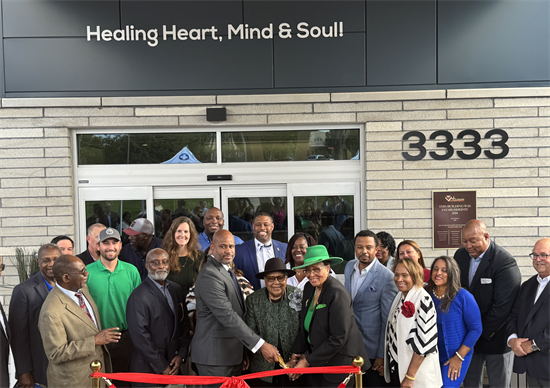 Group of people cut a ribbon to celebrate building opening