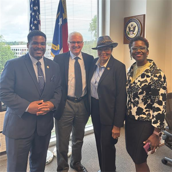 Rep. Adams poses in an office with three other people