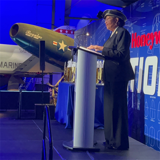 Rep. Adams stands at a podium and speaks to the Aviation Institute of Maintenance